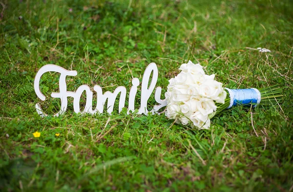 Οικογενειακά ξύλινα γράμματα και όμορφο γαμήλιο μπουκέτο — Φωτογραφία Αρχείου