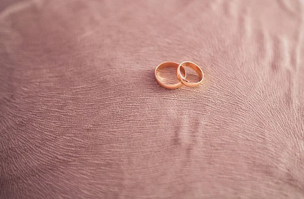 Arany jegygyűrűk, jegygyűrűk a kanapén — Stock Fotó