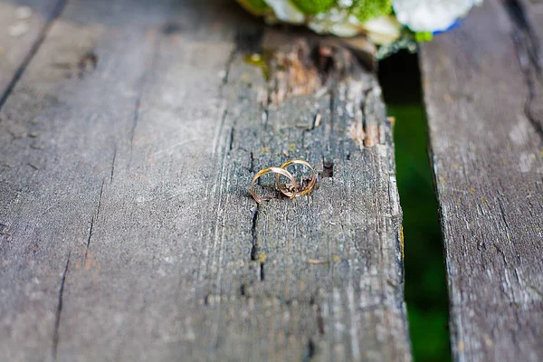 Dois anéis de casamento no chão de madeira — Fotografia de Stock