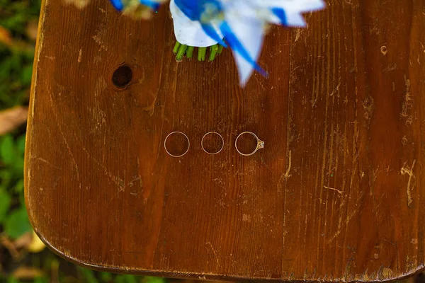 在木地板上的三个结婚戒指。 — 图库照片