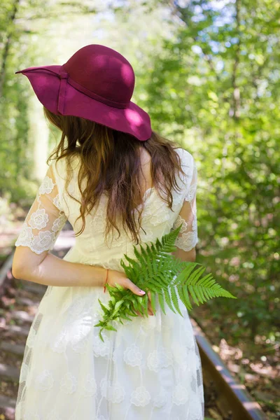 Dívka v bílých šatech s třešňovým kloboukem v lese — Stock fotografie