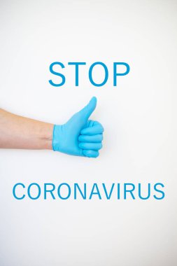 Mavi tek kullanımlık eldivenli bir adamın eli beyaz arka planda gibi görünüyor. Virüs koruması. Yazıt koronavirüsü durdurur..