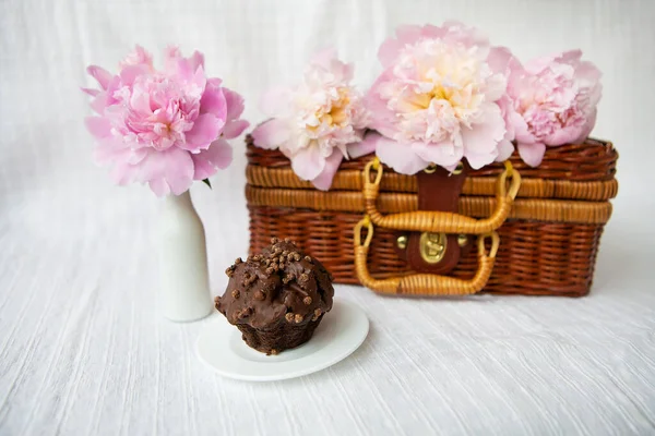 Schokoladenmuffins Und Schöne Rosa Pfingstrosen Liegen Auf Einem Hölzernen Koffer — Stockfoto