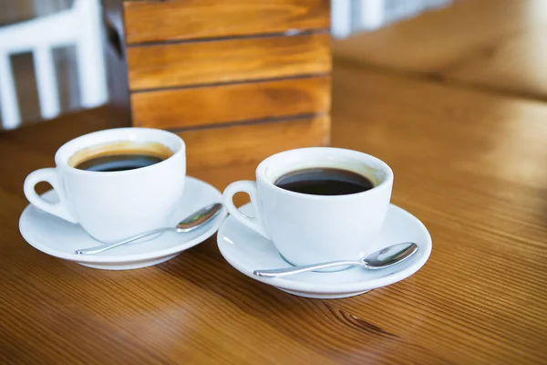 Twee kopjes koffie op een houten tafel, een plek voor tekst. — Stockfoto