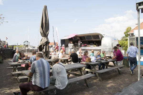 Hollanda, Friesland, Hindeloopen, july2018:Visitors, balık ve cips yeme Hindeloopen