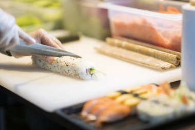 Japon restoranı, hazırlanmasında suşi rulo kesme Şef ellerde yakından 