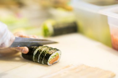 Japon restoranı, hazırlanmasında suşi rulo kesme Şef ellerde yakından 