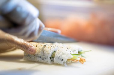 Japon restoranı, hazırlanmasında suşi rulo kesme Şef ellerde yakından 