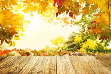 Günbatımına ahşap masa üzerinde renkli sonbahar yaprakları