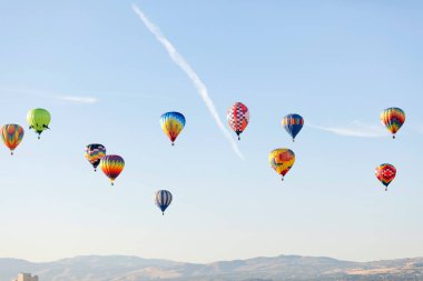 Mavi gökyüzünde uçan çok renkli sıcak hava balonu 