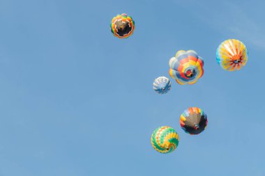 Mavi gökyüzünde uçan çok renkli sıcak hava balonu 