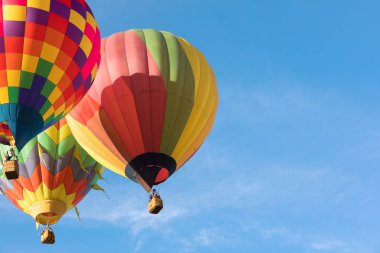 Mavi gökyüzü üzerinde her othe yakın uçan üç çok renkli sıcak hava balonları