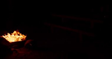 Gece kamp ateşinin alevleri, siyah arka planda yanan alevlerin yakın çekimi.