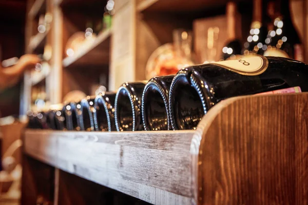 Bottles of red wine on a wooden shelf