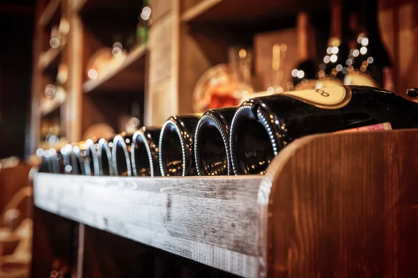 Rotweinflaschen auf einem Holzregal — Stockfoto