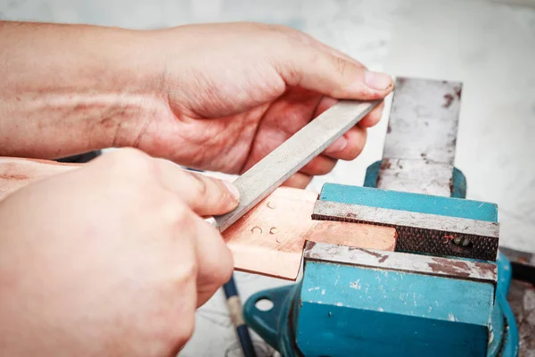 Grinding the copper billet with a file — Stock Photo, Image