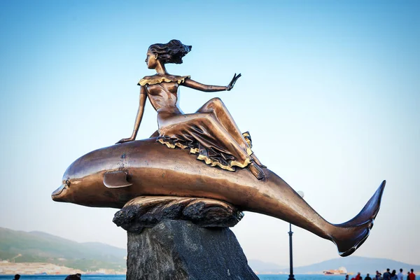 Una ragazza a cavallo di un monumento delfino a Novorossiysk — Foto Stock