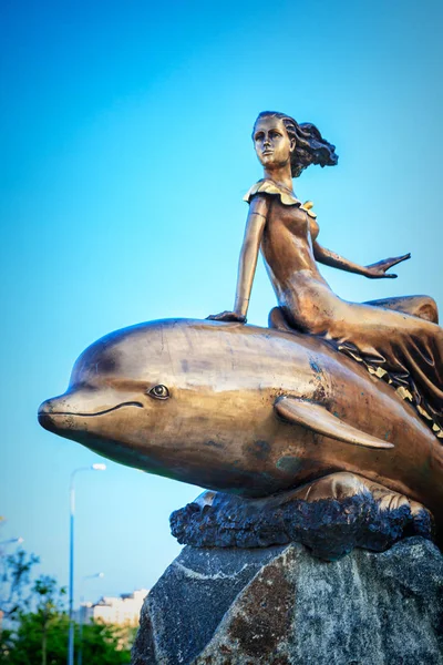Een meisje dat een dolfijn monument in Novorossiysk rijden — Stockfoto