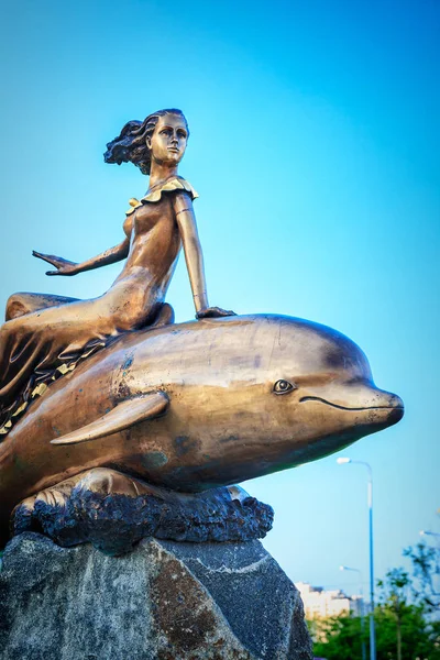 Egy lány, lovaglás a delfin-szobor-Novorossiysk — Stock Fotó