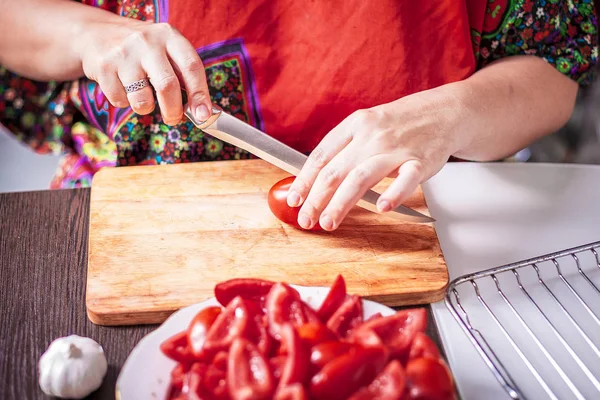 Женщина режет помидоры — стоковое фото