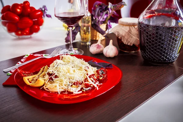 Leckere Spaghetti auf einem roten Teller serviert — Stockfoto