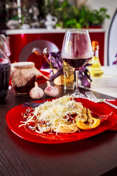 Leckere Spaghetti auf einem roten Teller serviert — Stockfoto