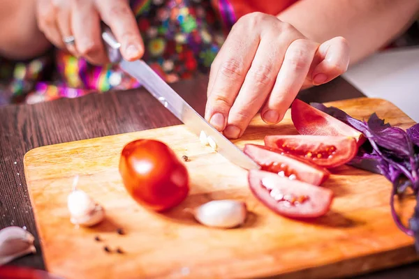 Женщина режет помидоры — стоковое фото