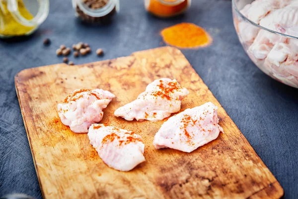 Ahşap kesme tahtası üzerinde baharat ile Çiğ tavuk kanatları — Stok fotoğraf
