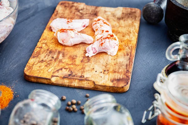 Ahşap kesme tahtası üzerinde baharat ile Çiğ tavuk kanatları — Stok fotoğraf