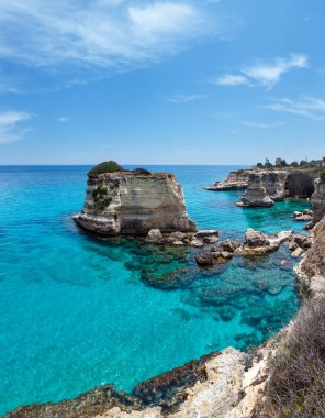 Uçurumlar, kayalık kemer ve yığında (faraglioni), Torre Sant Andrea, güzel deniz manzarası: Salento deniz kenarı, Puglia, İtalya. İki el silah sesi görüntü dikiş. Tanınmayan insanlar.