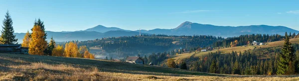 Morning Carpathian mountains and village hamlets on slopes (Yablunytsia village and pass, Ivano-Frankivsk oblast, Ukraine). High-resolution panorama of Gorgany mountain range.