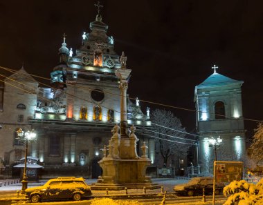Lviv, Ukrayna - 10 Aralık 2017: Gece kış cityscape aydınlatılmış. Bernardine Kilisesi ve Manastırı (kilise St. Andrew) üst. Ve anıt Dukla Saint John devam.
