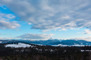 Akşam alacakaranlık kış bulutlu gün kar kaplı alp dağ sırtı (Ukrayna, Karpat Dağları, Chornohora aralığı - Hoverla, Petros ve diğer bağlar, Yablunytsia pass görünümünden sahne).
