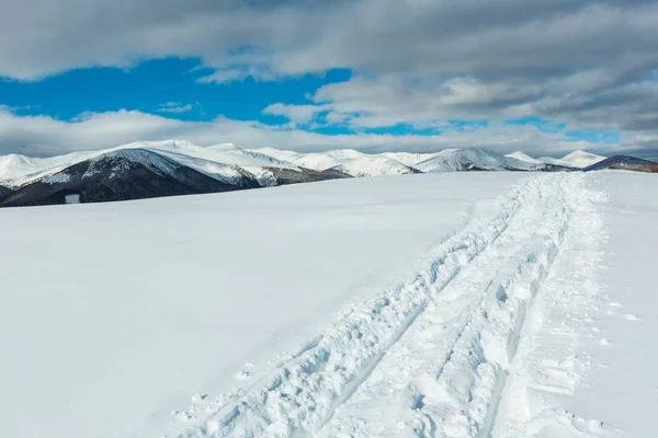 雪撬痕迹和脚印在冬山山顶和积雪覆盖风景如画的阿尔卑斯山 Chornohora 乌克兰 Dzembronya 村郊区宁静和平的看法 — 图库照片