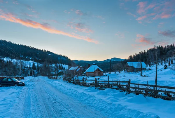 Daybreak sunrise morning winter mountain village snow covered street (Ukraine, Carpathian Mountains, tranquility peaceful Dzembronya village).