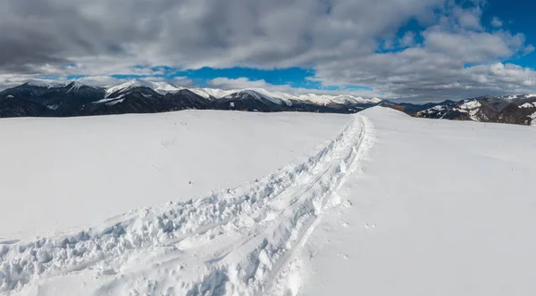 雪撬痕迹和脚印在冬山山顶和积雪覆盖风景如画的阿尔卑斯山 Chornohora 乌克兰 Dzembronya 村郊区宁静和平的看法 — 图库照片