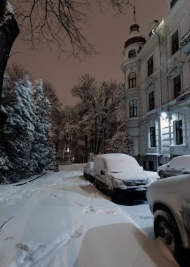 Güzel bir akşam alacakaranlık kış cityscape Lviv merkezi City, Ukrayna. Arabayı karla kaplı.