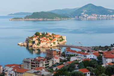 Sveti Stefan deniz adacık pembe plaj (Karadağ, Budva yakınındaki) ile sabah görünümü. Tanınmayan insanlar.