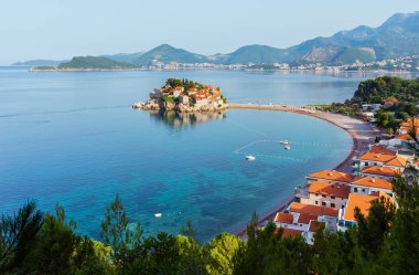 Sveti Stefan deniz adacık pembe plaj (Karadağ, Budva yakınındaki) ile sabah görünümü. Tanınmayan insanlar.