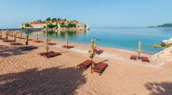 Pembe kumlu Milocher Beach ve Sveti Stefan adacık sabah görünümü (Karadağ, Budva yakınındaki). İnsanlar tanınmaz.