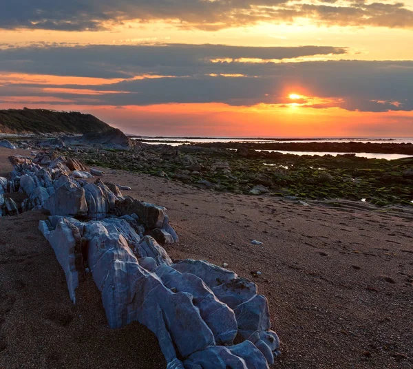 Tramonto vista mare dalla spiaggia rocciosa — Foto Stock