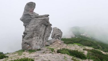 Büyük dikey taşlı kayalar ile Yaz dağ sırtı. Rüzgar, az bulutlu ve sisli. Karpat, Chornohora, Vuhatyj Kaminj, Ukrayna.