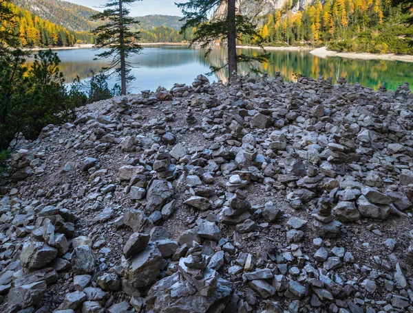 秋の穏やかな高山湖の近くの小さな石のピラミッドブレイまたはPragser Wildsee 南チロル ドロマイトアルプス イタリア 絵のような旅 四季折々の自然美のコンセプトシーン — ストック写真