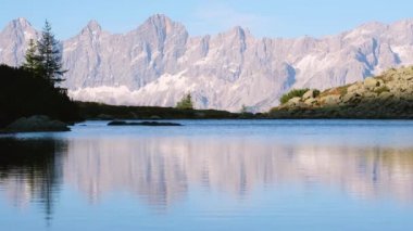 Sonbahar manzaralı bir akşam. Şeffaf, dalgalı suyu ve dağ yansımaları olan huzurlu bir göl. Spiegelsee veya Mittersee veya Mirror Lake, Reiteralm, Steiermark, Avusturya.