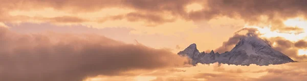 霧の雲と夕方曇りの空の景色で日光 雲の中に有名なドイツアルプスワッツマン山のトップシルエット 天気と気候の空の背景シーン — ストック写真