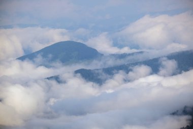 Dağların tepesindeki tüylü sabah bulutları. İklim, çevre ve hava durumu gökyüzü arkaplanı.