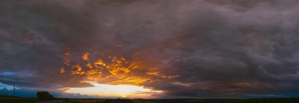 多云的夕阳黄昏的天空笼罩着春天的油菜籽黄色的田野 道路和乡村的山丘全景 自然季节 乡村美景概念及背景景致 — 图库照片