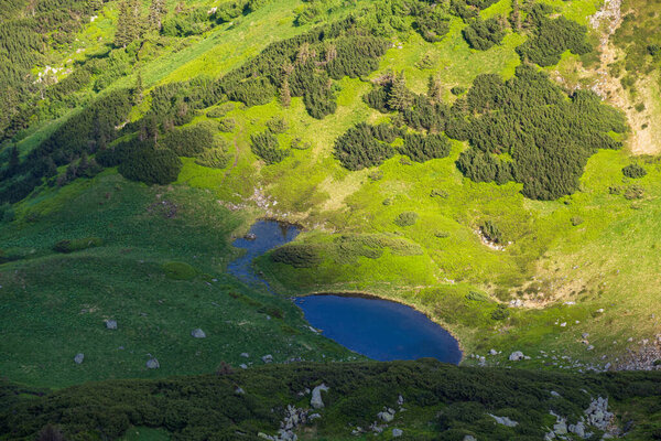 Summer mountain landscape with small lake in far. View from Marmaros Pip Ivan Mountain, Carpathian, Ukraine.