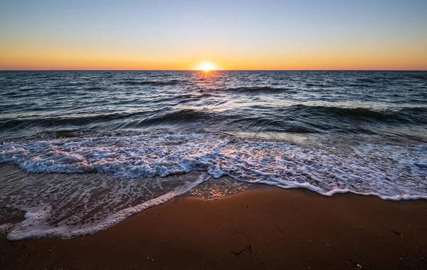 地平線の上に澄んだ朝の空と太陽とカラフルな海のビーチの日の出 — ストック写真