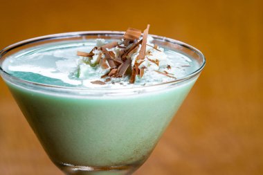 Klasik çekirge kokteyli ile krem şanti çikolata parçaları ile bir topak bir martini cam servis, yakın çekim